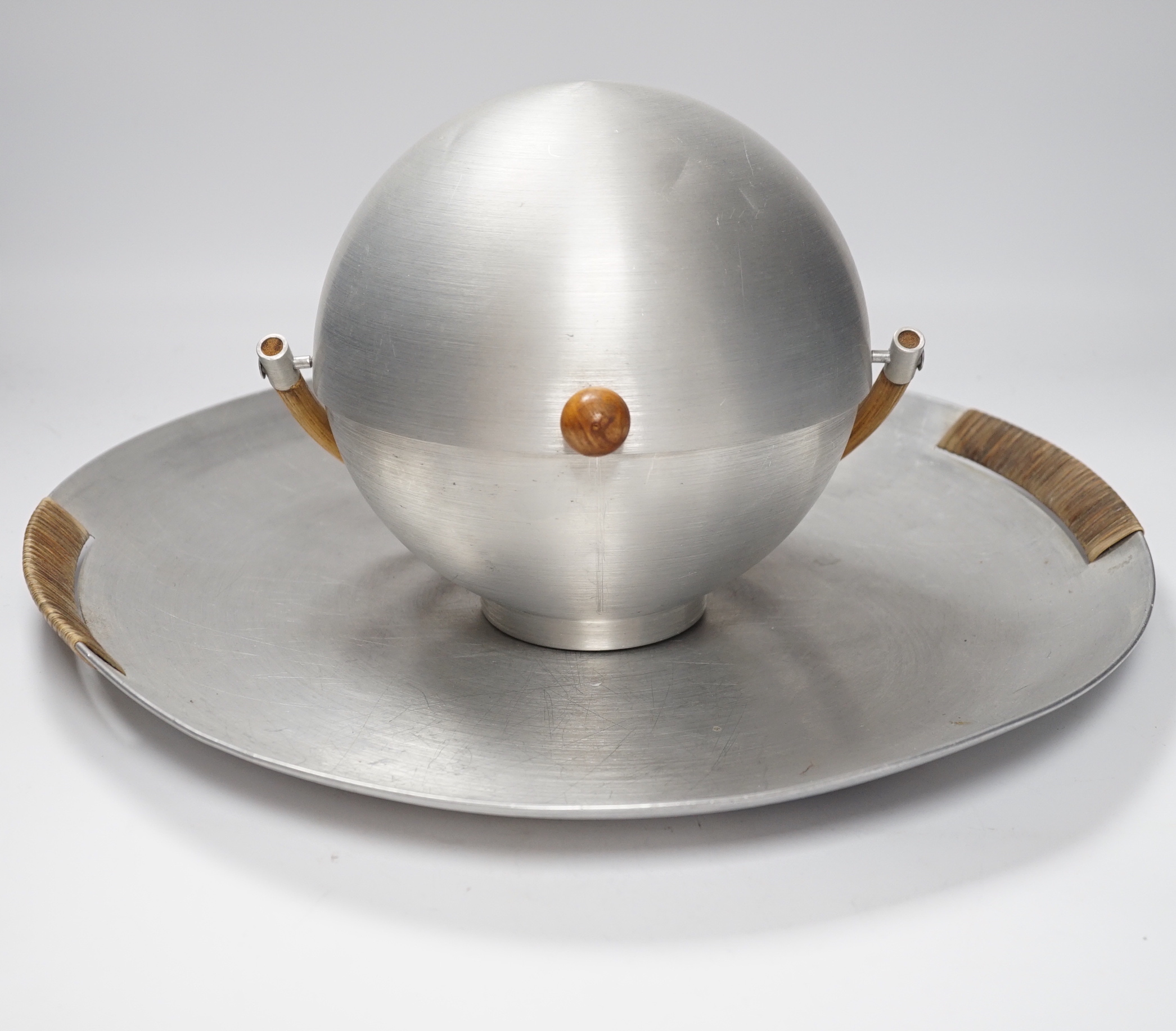 A Russell Wright spun aluminium ‘bun’ warmer and tray with woven handles, largest 45cm in diameter